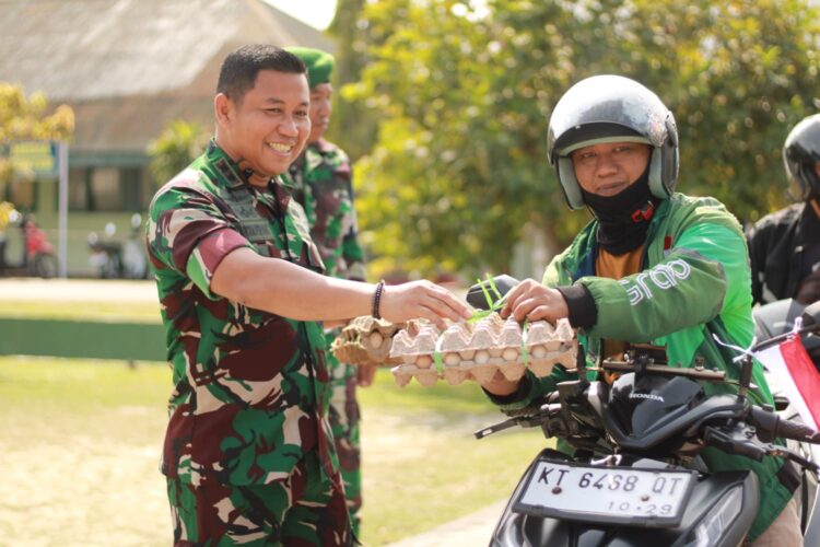 Dandim 0908/Bontang Letkol Inf Ardiansyah Menyerahkan Bantuan ke Ojol (Foto/Ari)